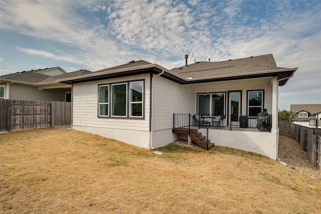 rear view of property featuring a lawn