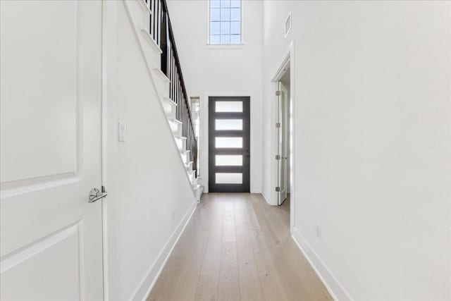 interior space with a high ceiling and light wood-type flooring