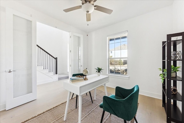 home office with light hardwood / wood-style flooring and ceiling fan