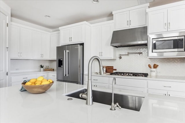 kitchen featuring stainless steel appliances, sink, white cabinets, and backsplash