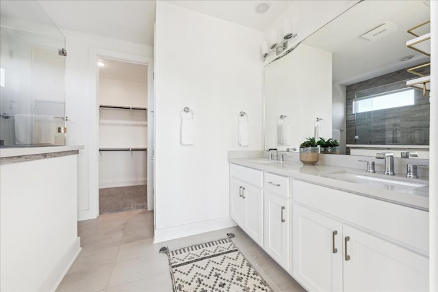 bathroom featuring walk in shower, vanity, and tile patterned flooring