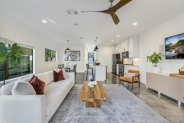 living room with concrete flooring, sink, and ceiling fan