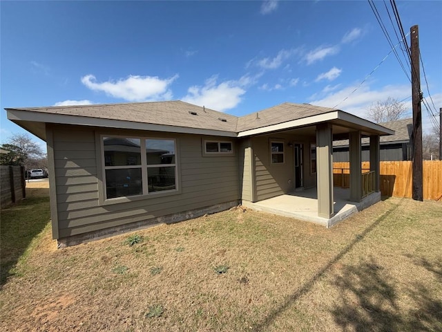 back of house with a patio area and a lawn