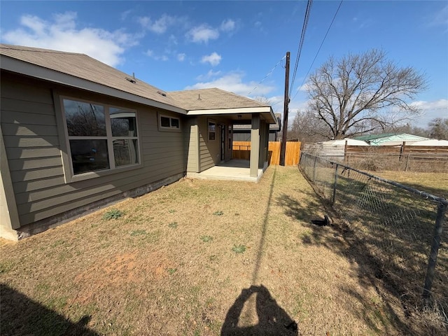 back of house featuring a lawn and a patio