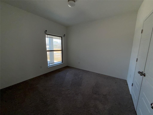 unfurnished room with dark carpet