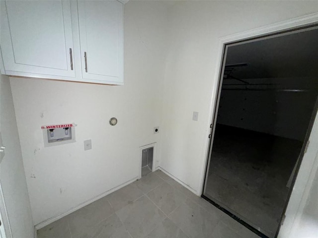 washroom featuring cabinets, electric dryer hookup, washer hookup, and light tile patterned floors