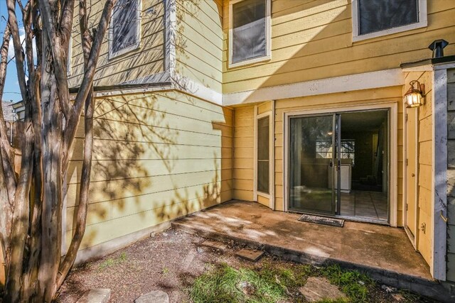 view of exterior entry with a patio area