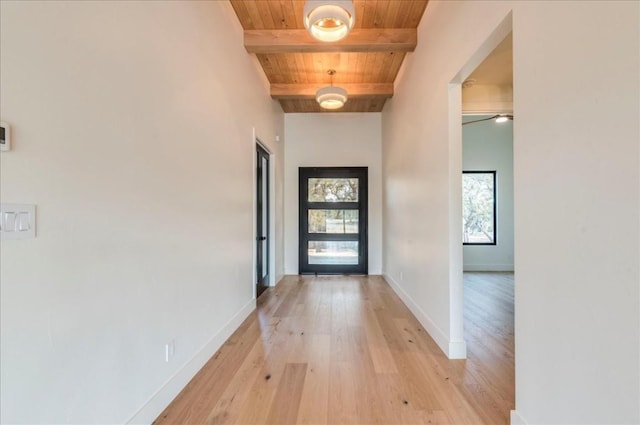 doorway with beamed ceiling, wooden ceiling, baseboards, and light wood-style floors