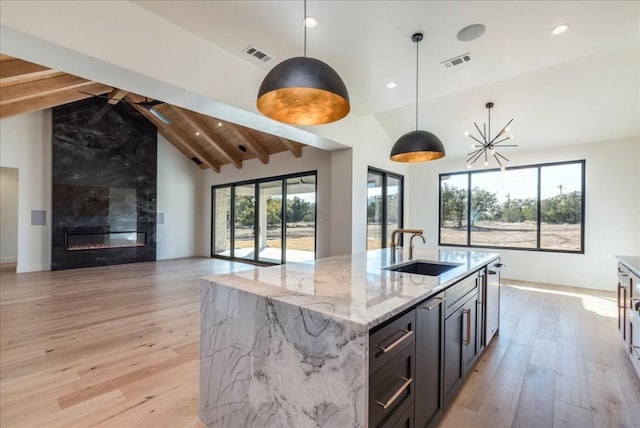 kitchen with open floor plan, visible vents, a sink, and light wood-type flooring