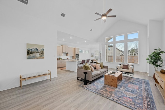 living room featuring ceiling fan, high vaulted ceiling, and light hardwood / wood-style flooring