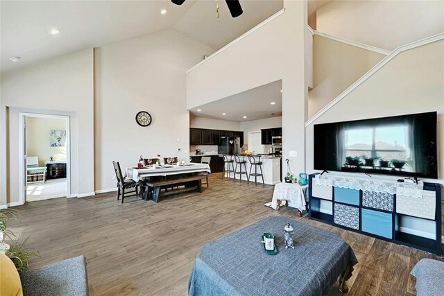 living room featuring ceiling fan, wood-type flooring, and high vaulted ceiling