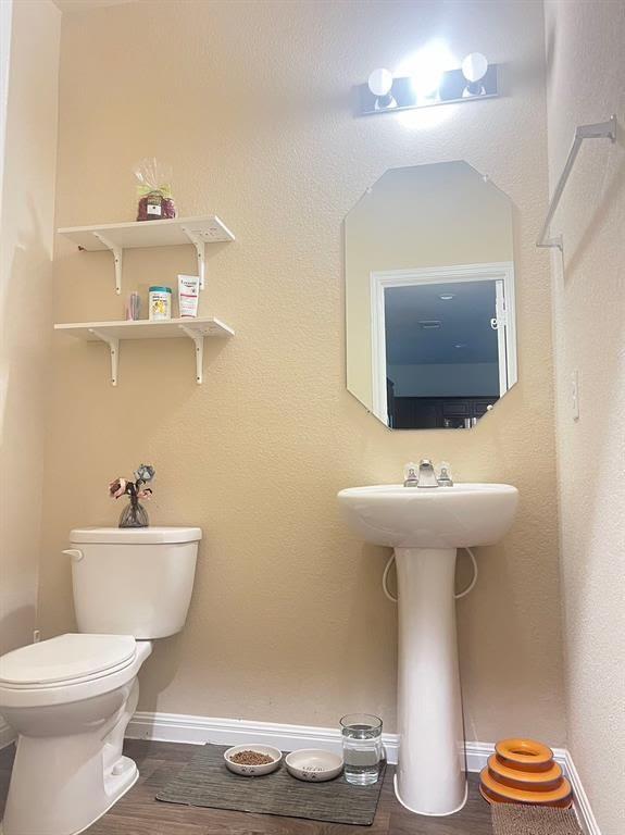 bathroom with hardwood / wood-style floors and toilet