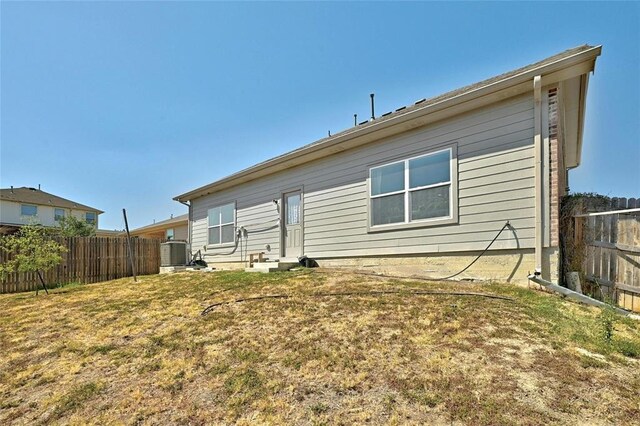 rear view of property with a yard and central AC unit