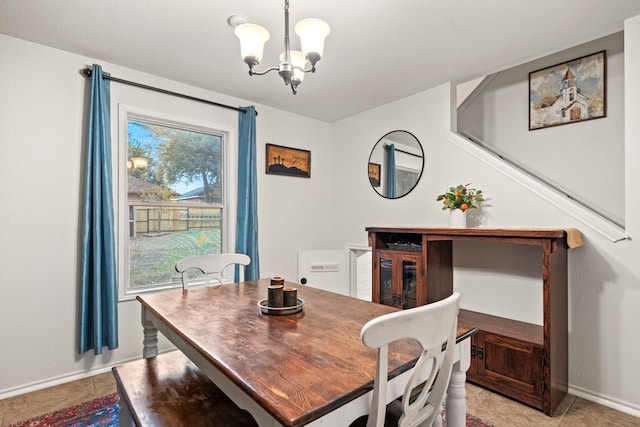 tiled dining room with a chandelier