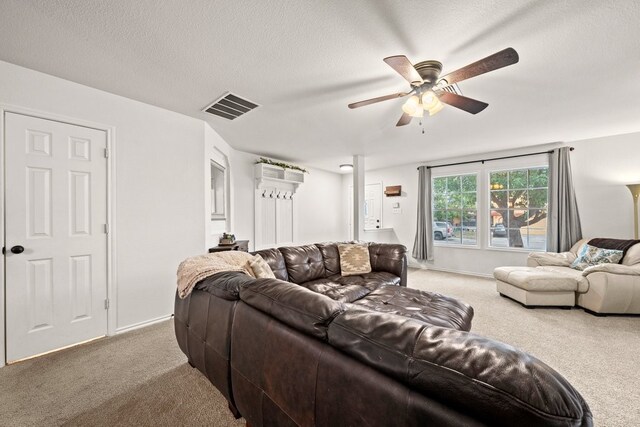 living room with ceiling fan, carpet, and a textured ceiling