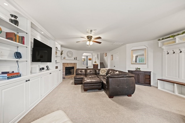 living room with built in shelves, ceiling fan, a brick fireplace, and light carpet