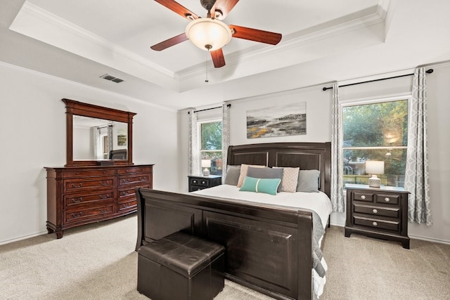 bedroom with ornamental molding, a raised ceiling, and light carpet