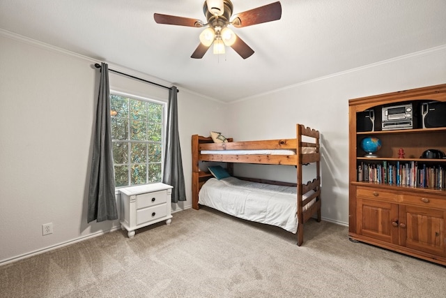 carpeted bedroom featuring crown molding and ceiling fan