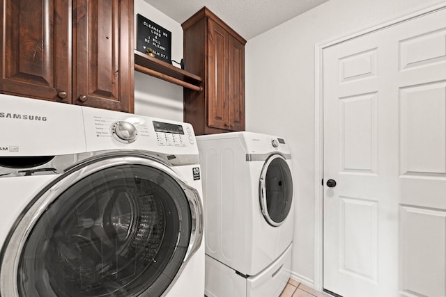 washroom featuring cabinets, a textured ceiling, washer and dryer, and light tile patterned floors