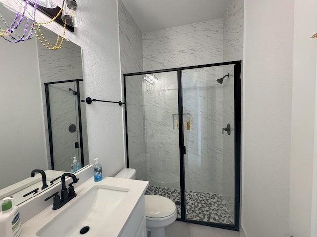 bathroom with vanity, a shower with shower door, and toilet