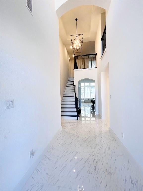 interior space with a high ceiling and a chandelier