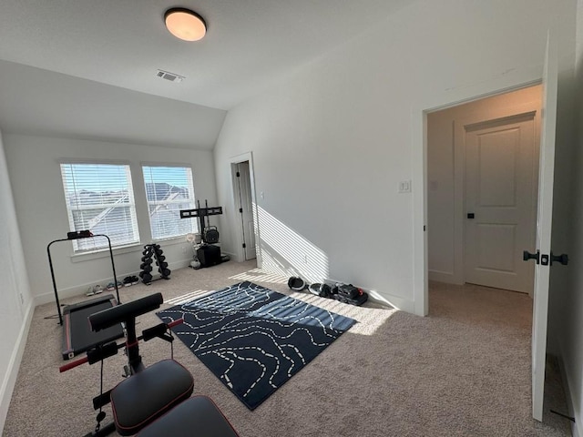 workout area with vaulted ceiling and light colored carpet