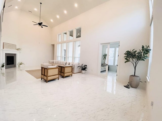 living room featuring ceiling fan, high vaulted ceiling, and a wealth of natural light