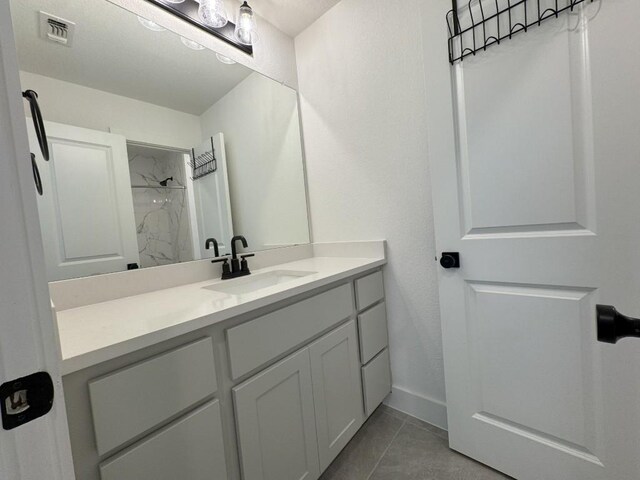 bathroom featuring vanity and tiled shower