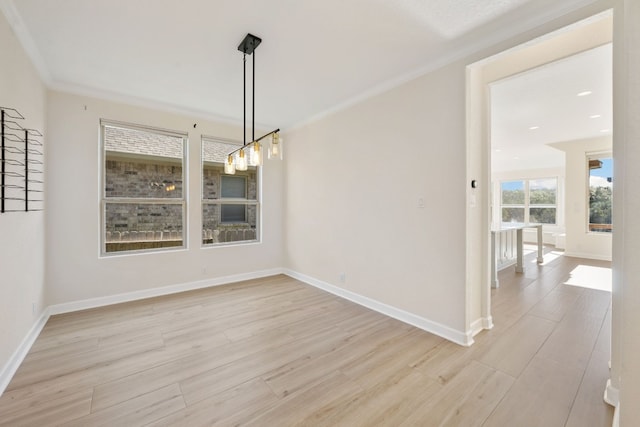 unfurnished dining area with ornamental molding and light wood-type flooring