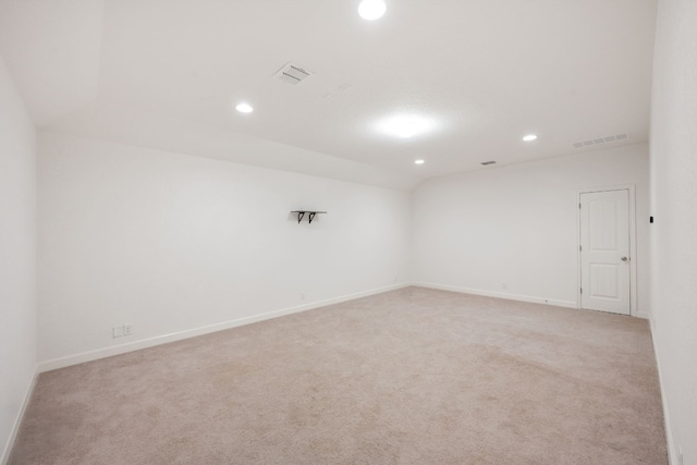 carpeted spare room featuring vaulted ceiling