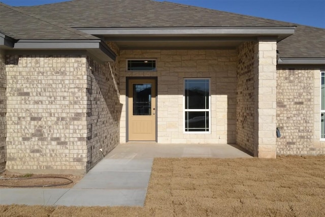 view of exterior entry with a yard