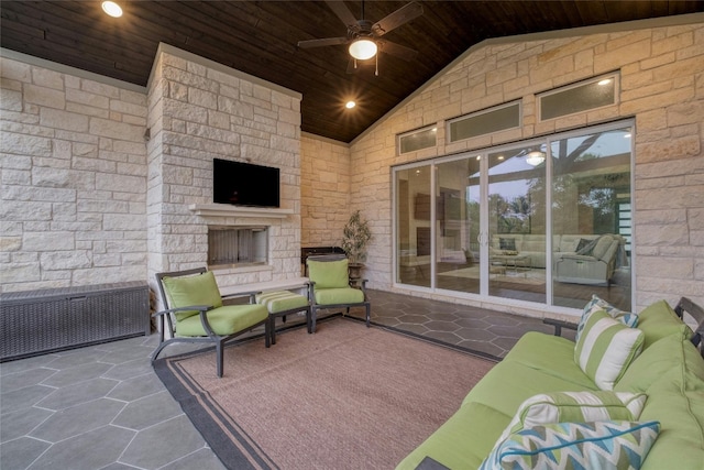 view of patio / terrace featuring ceiling fan and an outdoor living space with a fireplace