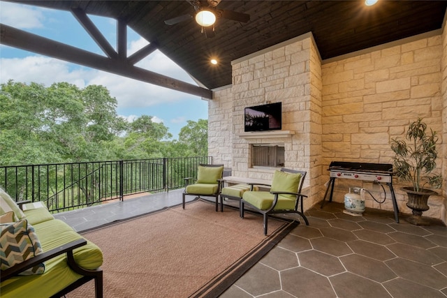 view of patio / terrace featuring ceiling fan and an outdoor stone fireplace