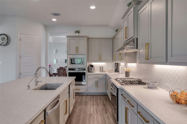 kitchen with stainless steel appliances, tasteful backsplash, sink, and gray cabinetry