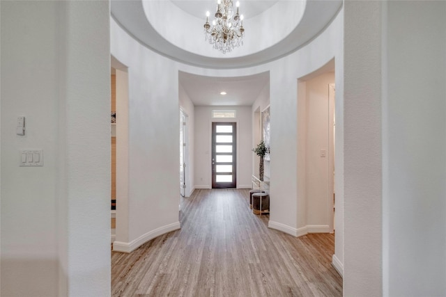 entrance foyer featuring light hardwood / wood-style floors and a notable chandelier