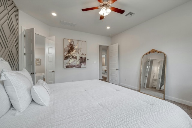 carpeted bedroom with ensuite bathroom and ceiling fan