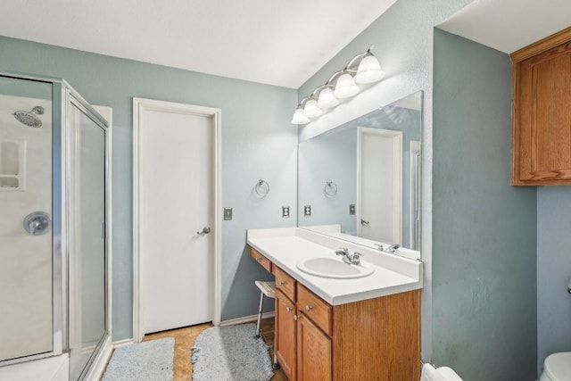 bathroom featuring a shower with door, vanity, and toilet