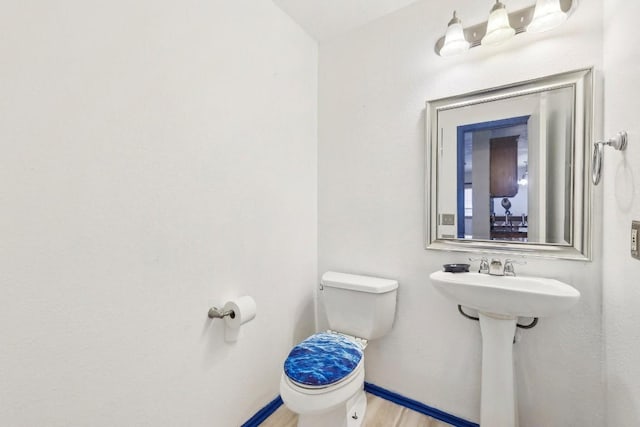 bathroom featuring hardwood / wood-style floors and toilet