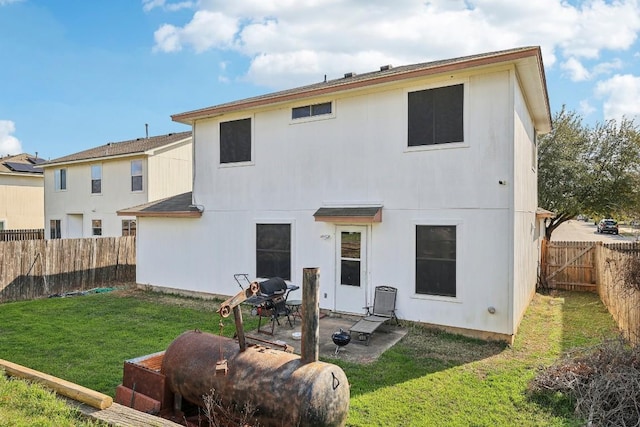 back of house with a lawn and a patio area