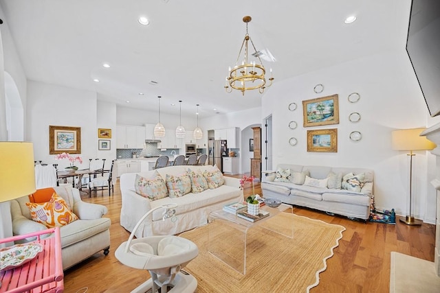 living room featuring a chandelier and light wood-type flooring