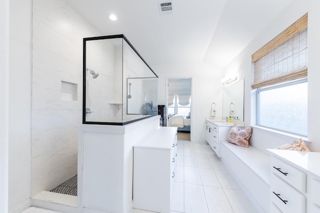 bathroom with vanity, tile patterned flooring, and a tile shower