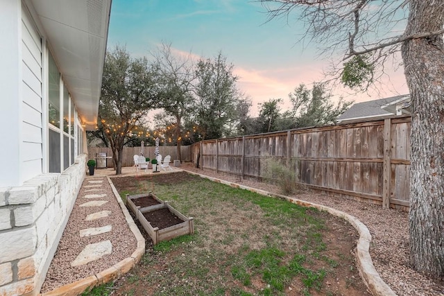 yard at dusk featuring a patio