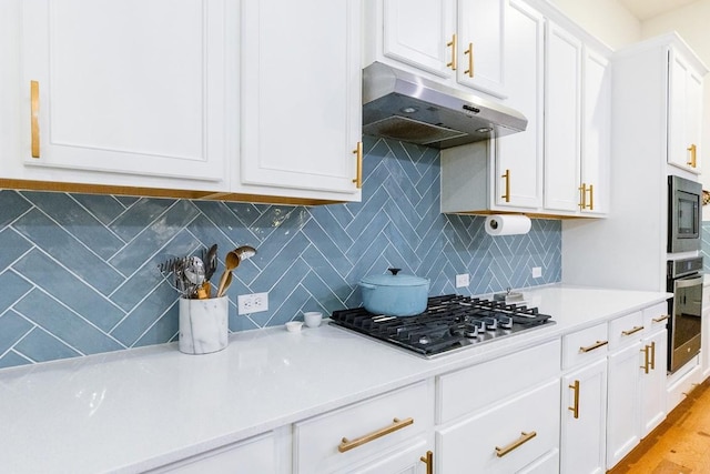 kitchen featuring tasteful backsplash, appliances with stainless steel finishes, white cabinets, and light hardwood / wood-style floors