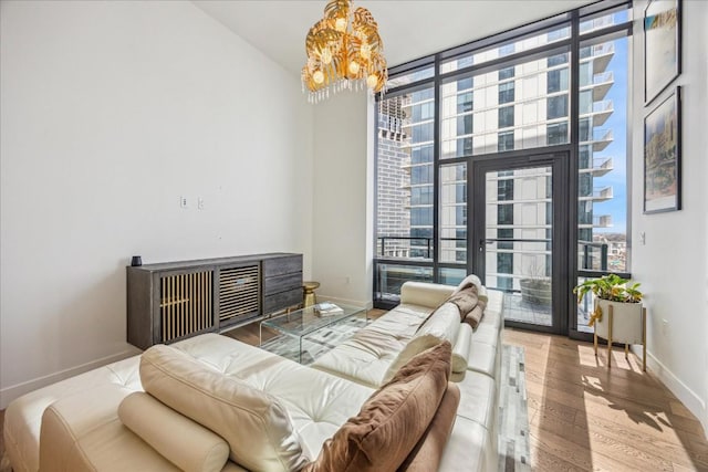 bedroom with hardwood / wood-style flooring, floor to ceiling windows, access to outside, and an inviting chandelier