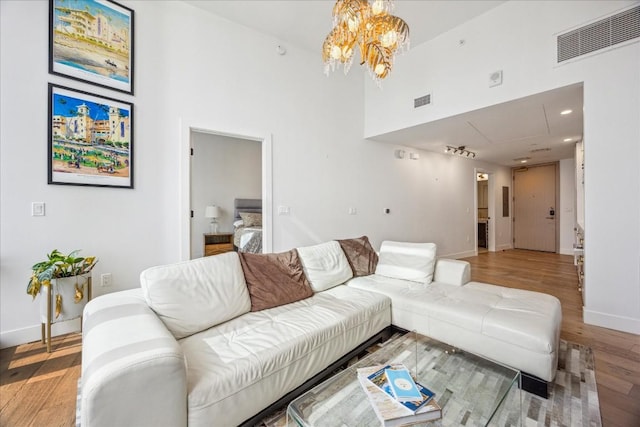 living room featuring a high ceiling, hardwood / wood-style floors, and an inviting chandelier