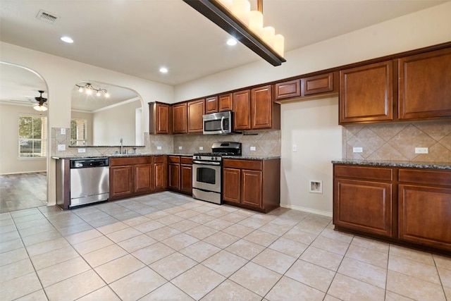 kitchen featuring tasteful backsplash, sink, stainless steel appliances, and stone countertops