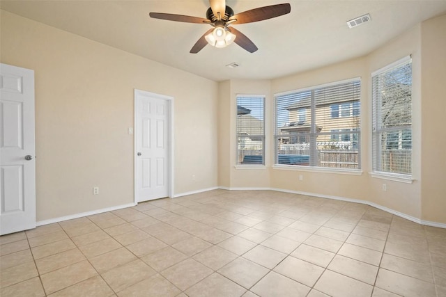 spare room with ceiling fan and light tile patterned flooring