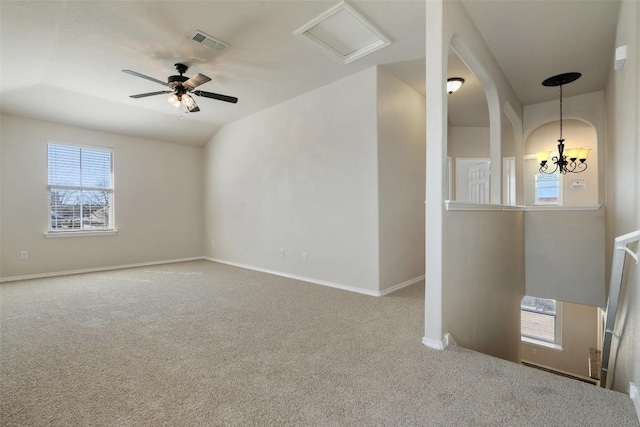 carpeted empty room with vaulted ceiling and ceiling fan with notable chandelier