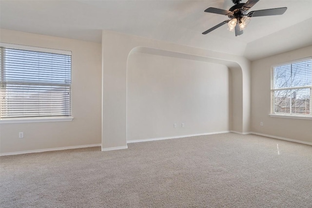 empty room featuring lofted ceiling, carpet floors, and ceiling fan