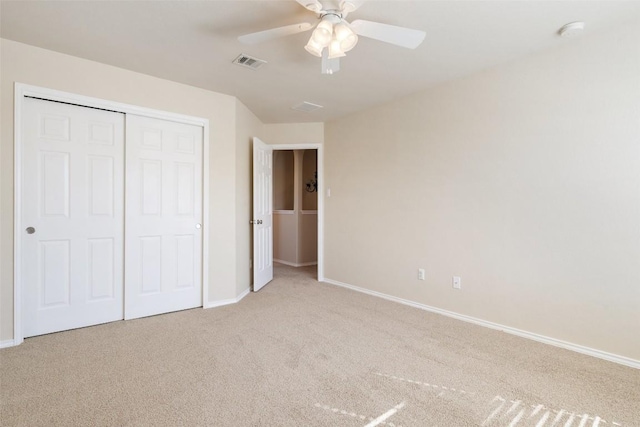 unfurnished bedroom featuring light colored carpet, ceiling fan, and a closet